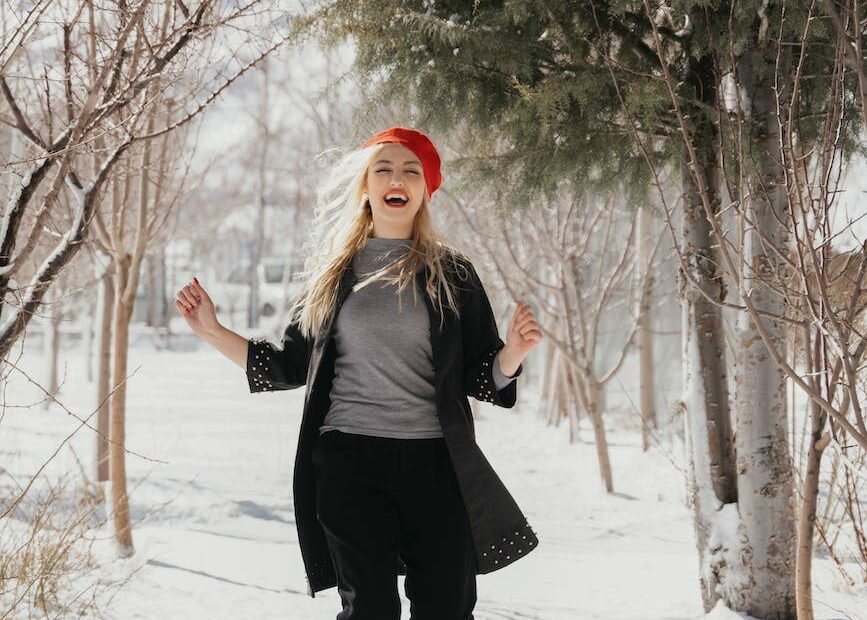woman in red beret running through snow