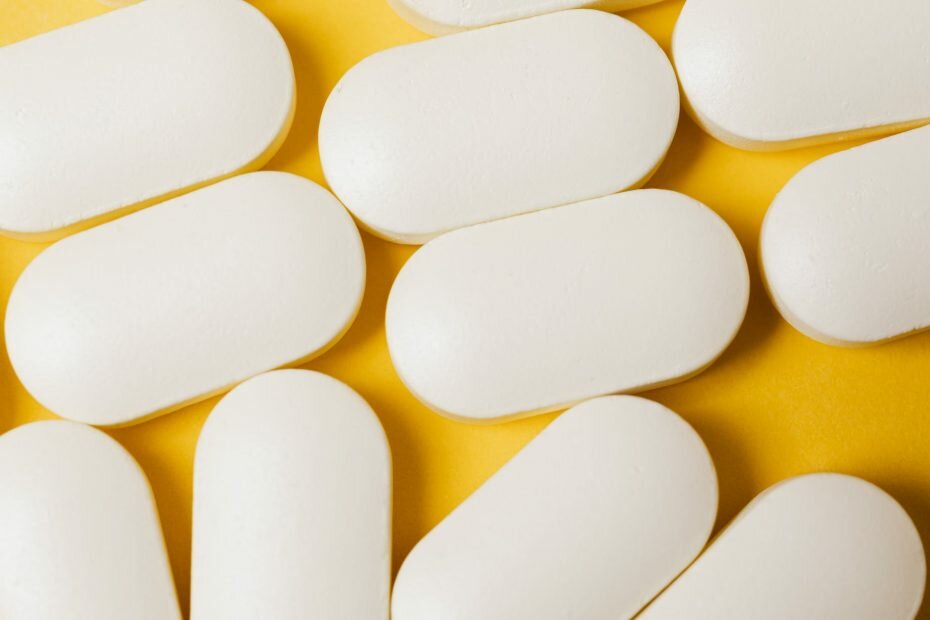 heap of pills on yellow background